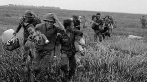 Vietnamesiska soldater evakuerar vuxna och barn vid Duc Hue i april 1974. Vietnamesiska soldater bär barn mot en helikopter.