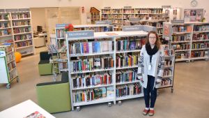 Biblioteksfunktionär Lena Pelkonen och så gott som alla bokhyllor ryms på en enda bild. Lena Pelkonen - bibliotekarie vid Vårberga bibliotek i Borgå.