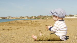 Liten kille på strand.