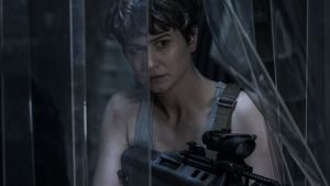 Daniels (Katherine Waterstone) tar det säkra före det osäkra. Daniels (Katherine Waterstone) siktar med sitt vapen genom en plastduk.