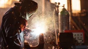 Industri medför alltid en risk för grundvattenområden, heter det i tjänstemannaberedningen inför mötet. Person som utför metallarbete med visir, gnistor i mörk omgivning.