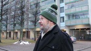 Eero Minkkinen är sekreterare i Havshagen-sällskapet. Bakom honom syns Hagnäskajen 18, ett av de husbolag som berörs mest av stadens planer på en ny spårvagnsrutt. Husbolagen och Havshagen-sällskapet vill att spårvagnen istället ska köra på norra sidan om Havshagen. Kronbroarna