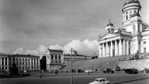 Helsinki, Senaatintori. Helsingin yliopisto ja yliopiston kirjasto sekä Suurkirkko (myöh. Helsingin tuomiokirkko). Autoja pysäköitynä kadun varrelle.
