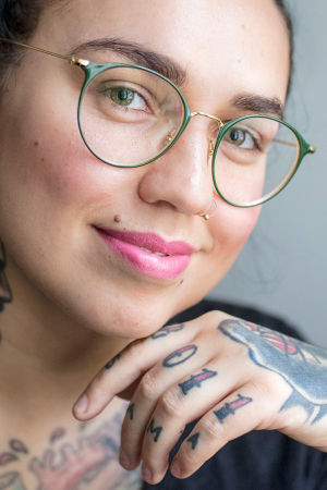 Natalia Tolmatsova katsoo kameraan, vasen käsi koskettaa leukaa.