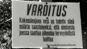 Jazzyleisöä varotetaan uimisesta Kokemäenjoessa vuonna 1969. Kyltti Kokemäenjoen rannassa varoittaa vuonna 1969 Pori Jazzin yleisöä uimisesta saastuneessa vedessä.