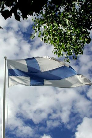 Suomen lippu liehuu taivasta vasten.