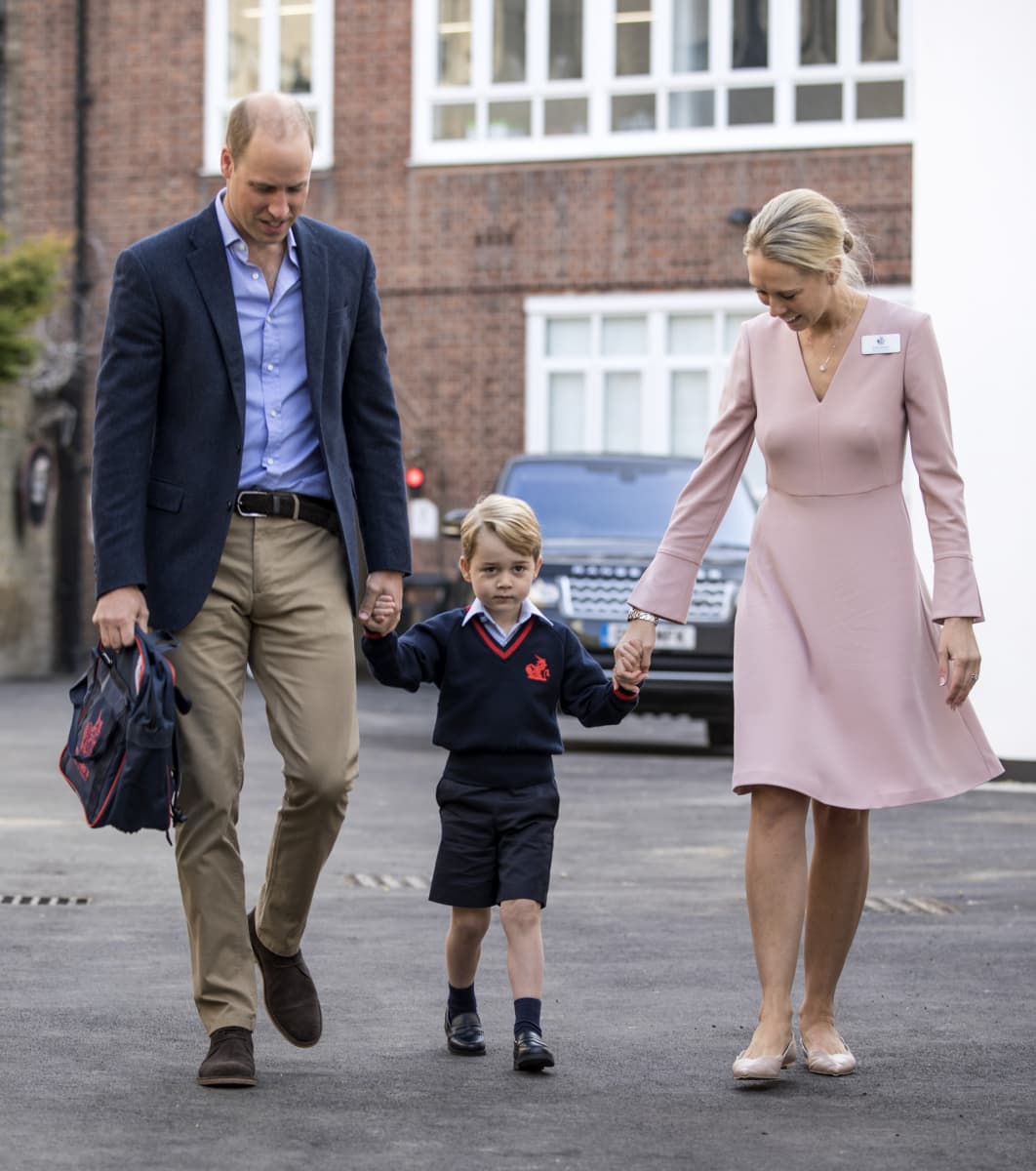 Prinssi George kävelemässä käsi kädessä isänsä prinssi Williamin ja alakoulunsa rehtorin Helen Haslemin kanssa.