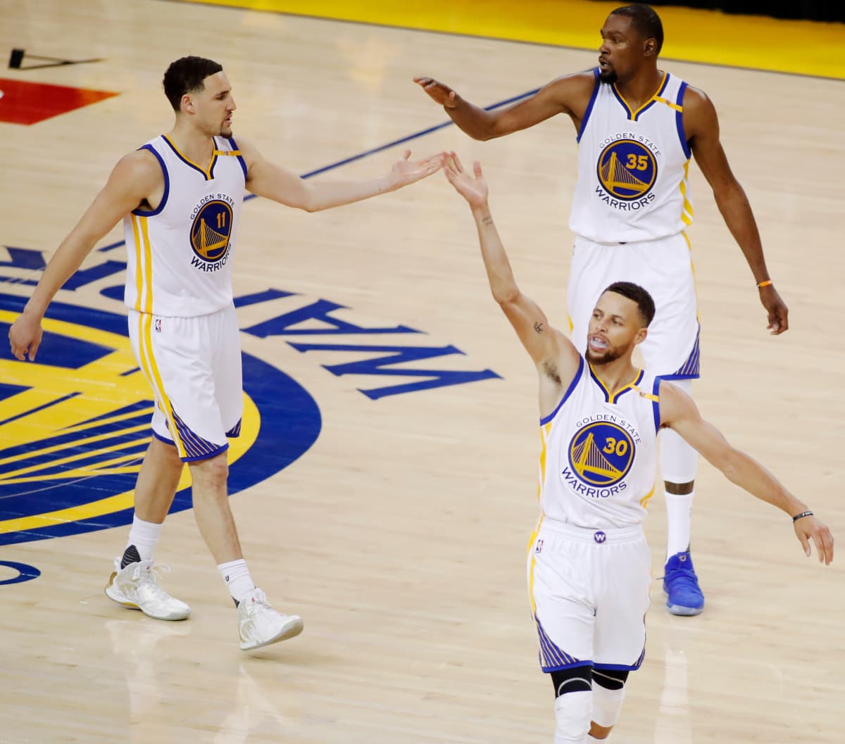 Golden State Warriorsin Stephen Curry, Klay Thompson ja Kevin Durant juhlivat voittoa. 