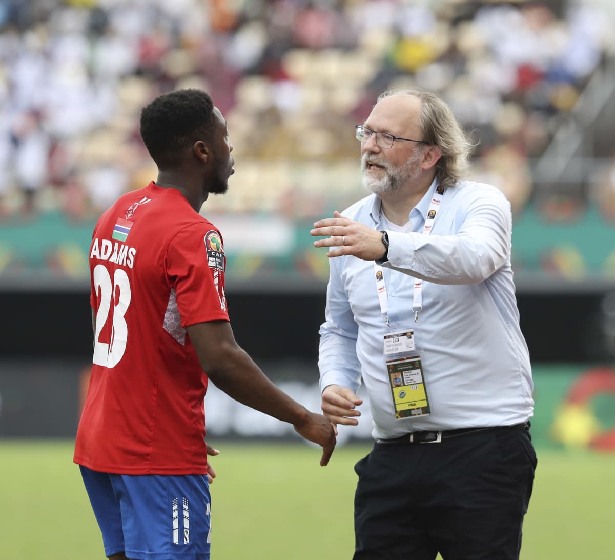 Päävalmentaja Tom Saintfiet opastaa gambialaista pelaajaa Afrikan mestaruusturnauksessa.