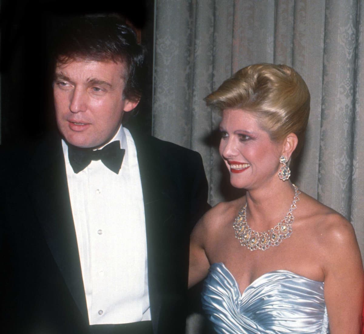 Donald ja Ivana Trump juhla-asuissa. Donaldilla on smokki ja Ivanalla siniharmaa iltapuku ja suuret korut.