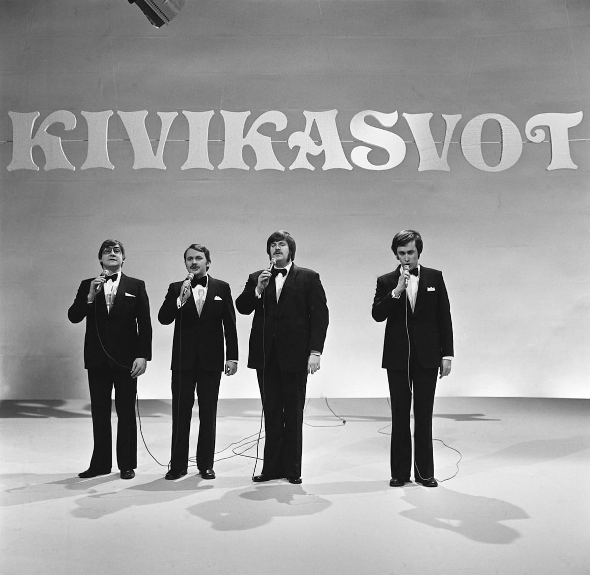 Kivikasvot-ryhmän jäsenet esiintyvät lavalla (mustavalkoinen kuva)
