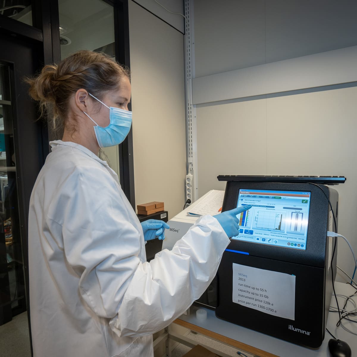 Tutkija Sari Hannula tutkii sekvensaattorin näyttöä FIMMin laboratoriossa.