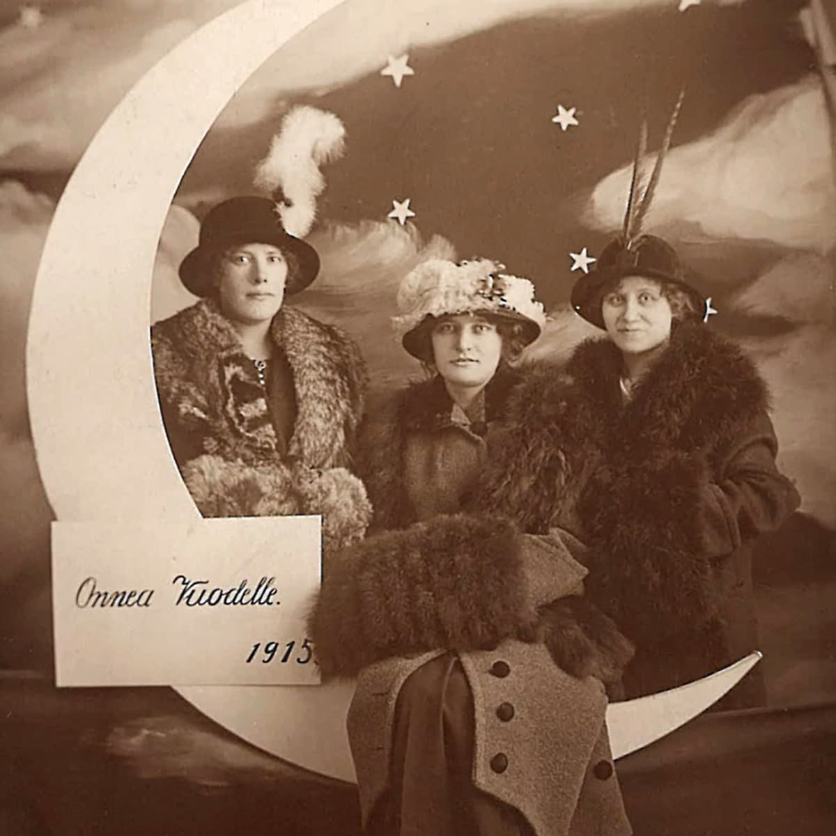 valokuvastudiossa kuunsirppikulissi ja kolme naista vuonna 1914 