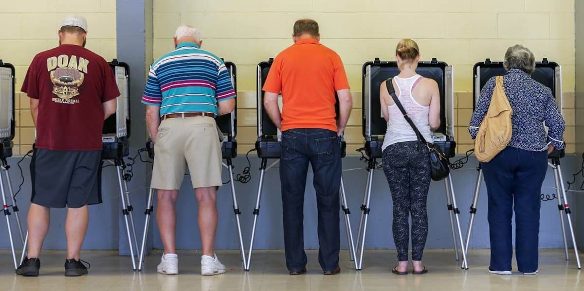 Rivi ihmisiä äänestyskopeissa. 