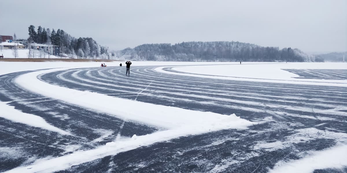 Jyväsjärven jälle aurattu retkiluistelurata. Luistelijoita radan kaarteessa. 