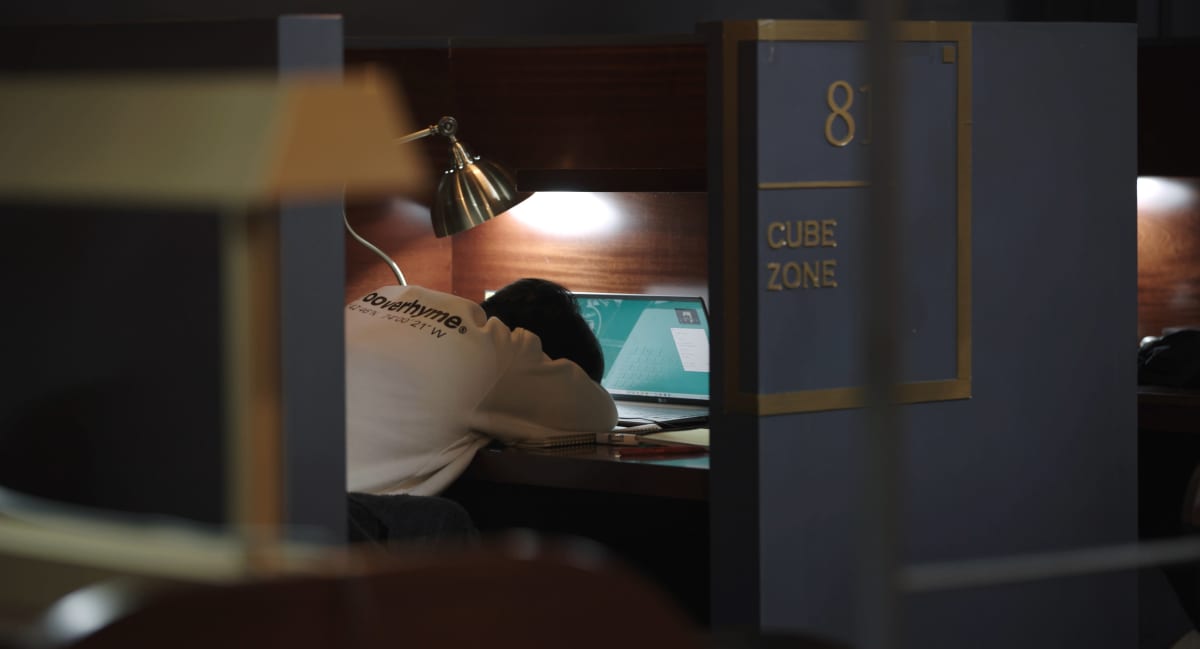 Korealainen lukukahvila, mies nukkuu tietokoneen ääressä.