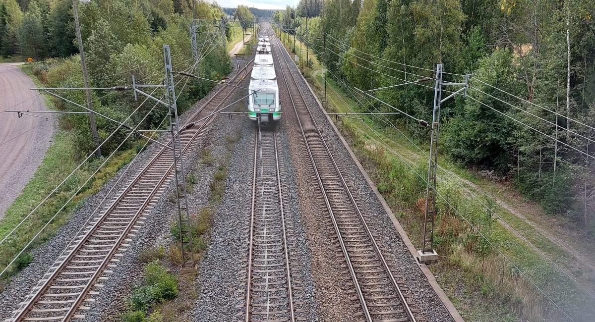 Ylhäältä ylikulkusillalta kuvattu junarata, jossa lähijuna tulee kohti kameraa. 