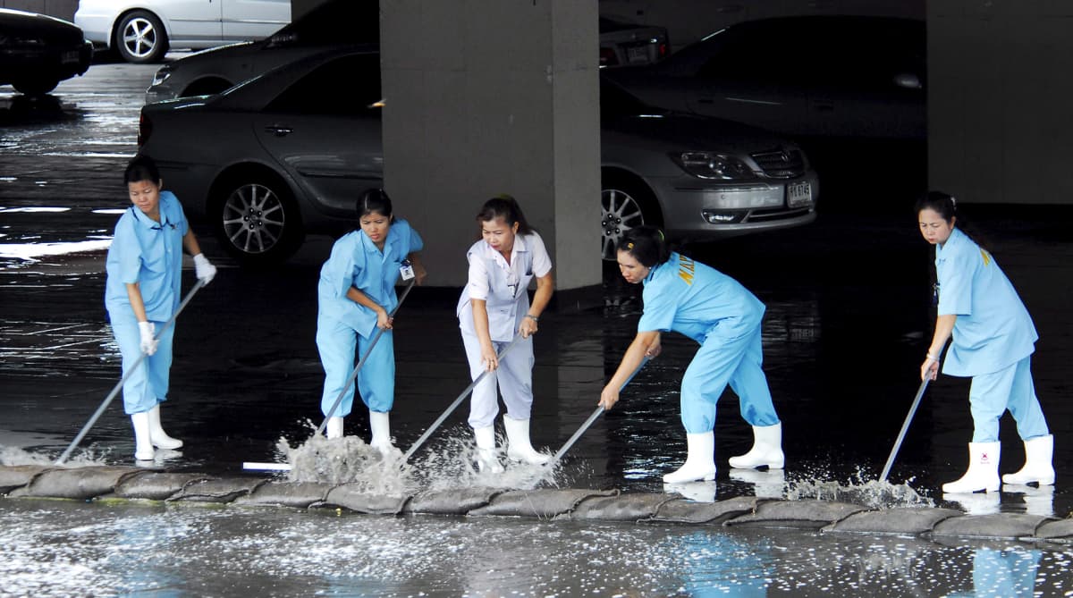 Monsuunisateiden aiheuttamaa tulvaa torjuttiin Bangkokissa työntämällä vettä hiekkasäkeistä tehdyn tulvasuojan yli toukokuussa 2007.