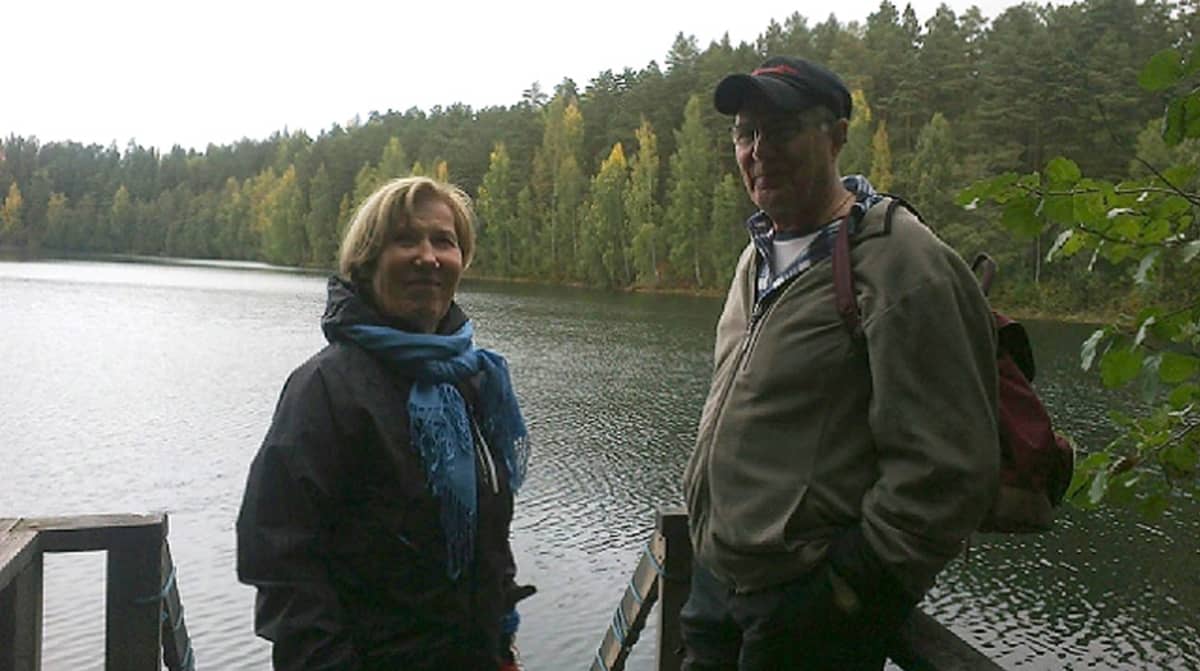 Nainen ja mies seisovat järvenrannalla laiturilla