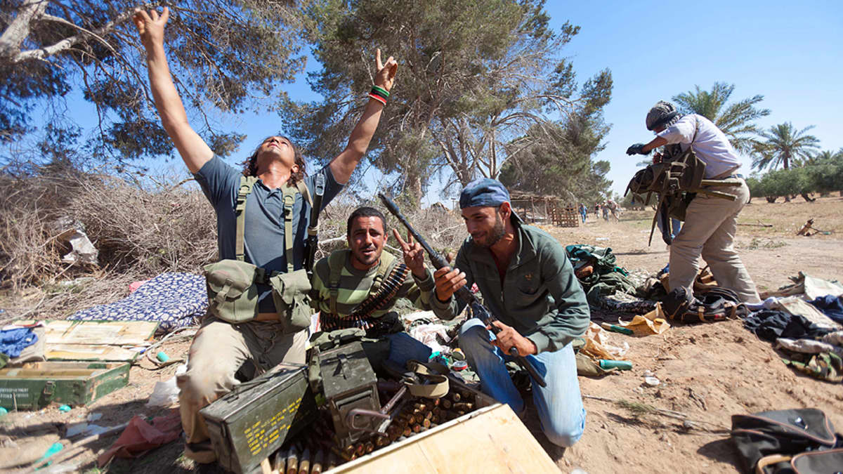 Libyalaiset kapinallissotilaat riemuitsevat taisteluiden jälkeen Muammar Gaddafin joukoilta saaliiksi saaduista aseista ja ammuksista.