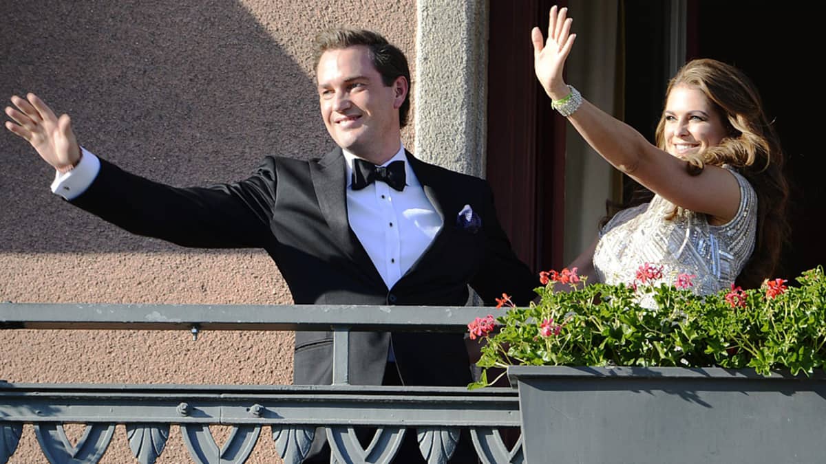 Prinsessa Madeleine ja hänen sulhasensa Chris O'Neill vilkuttavat Tukholman Grand Hotelin parvekkeelta.