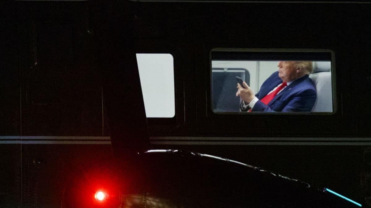 Donald Trump katsoo puhelintaan.