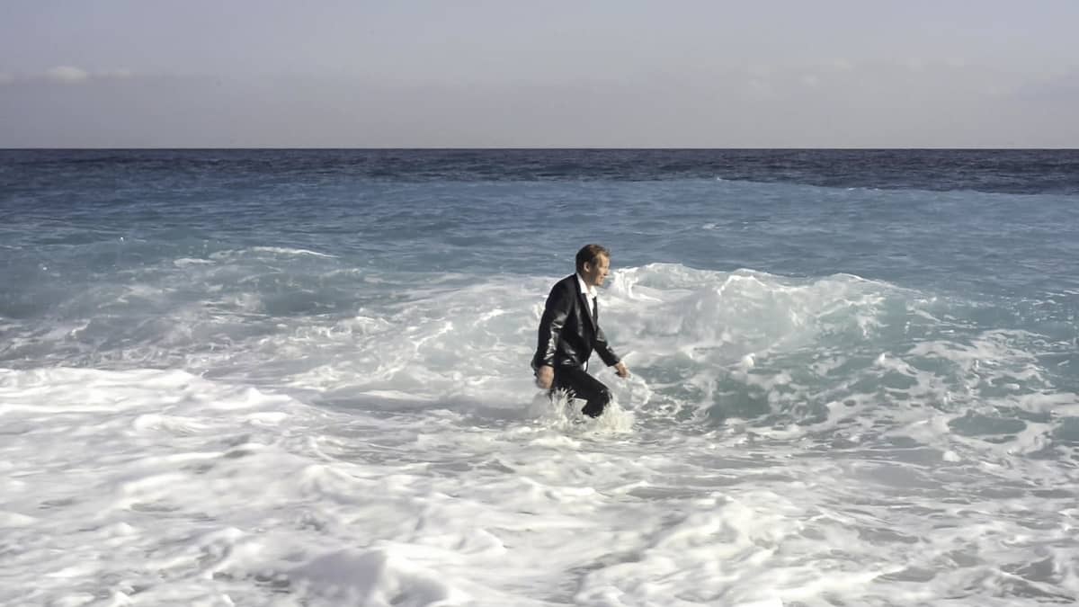 Niko Saarela kävelee meressä. Kuva Noora Geagean videoteoksesta STRUGGLE: Untitled (2014).
