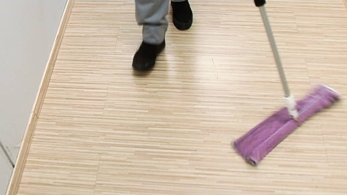 Siivooja moppaa lattiaa.