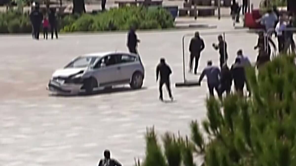 Mies hyppää jalat edellä autoon pysäyttääkseen holtittomasti ajaneen kuljettajan Albaniassa
