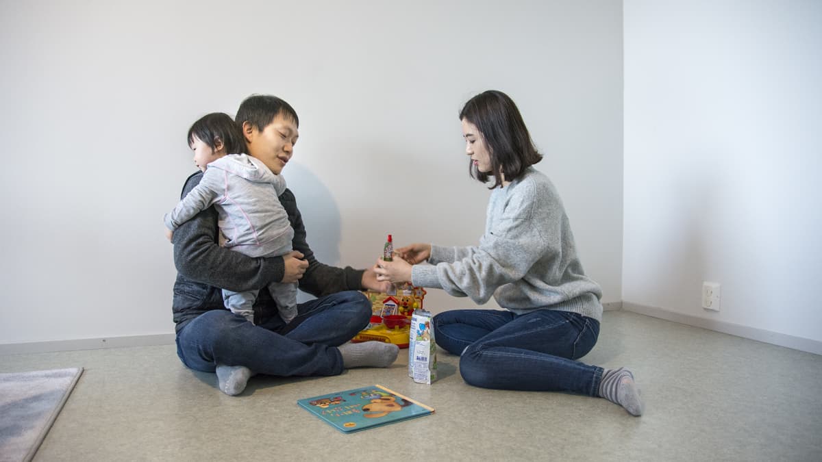 Isä Hakhyun Kim, äiti Dami Park ja Seo Woo -vauva tutkivat lastenkirjaa.
