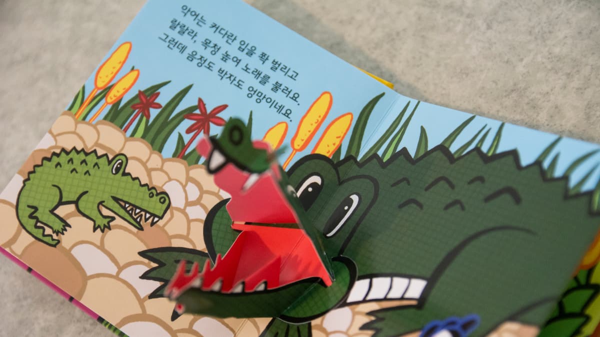 Lastenkirja, jossa korealaista tekstiä ja krokotiili.