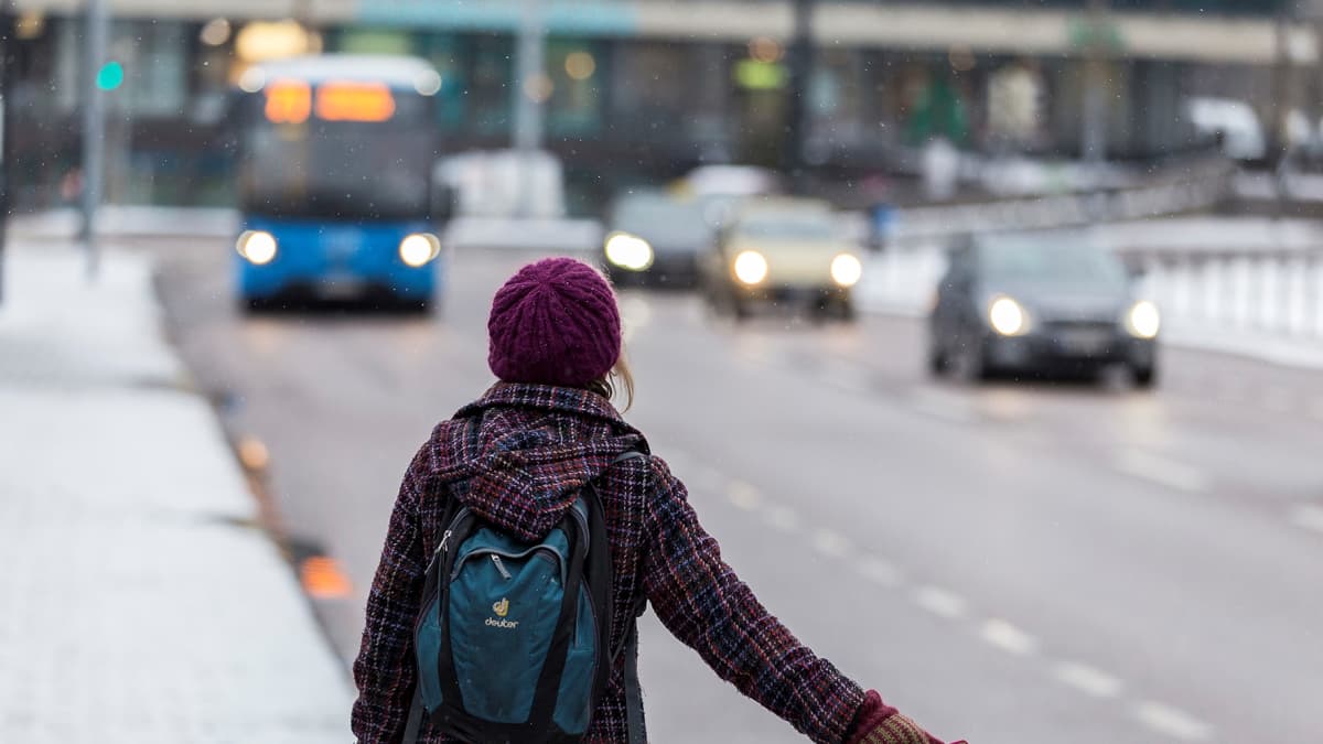 Matkustaja näyttää pysähtymismerkkiä bussille.