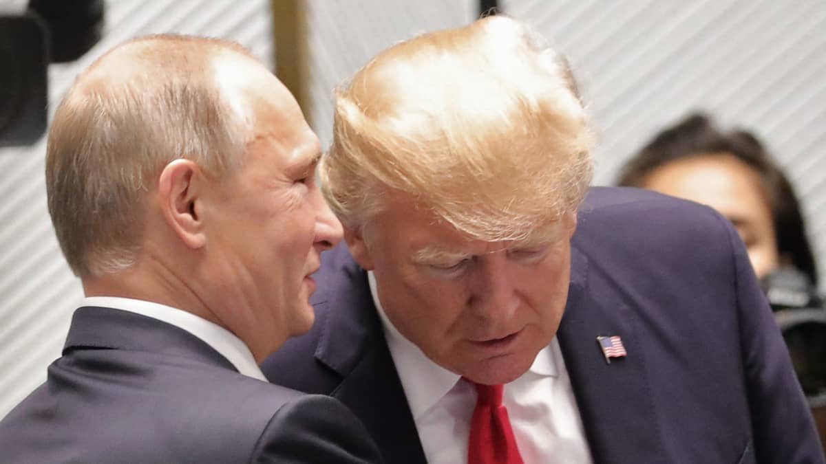 Presidentti Vladimir Putin kuiskaa presidentti Donald Trumpin korvaan marraskuussa 2017.