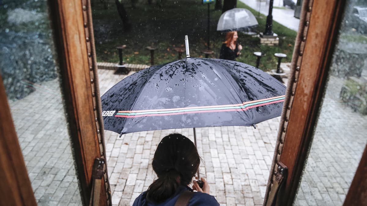Nainen astuu ulos sateeseen Kiovassa, Ukrainassa.