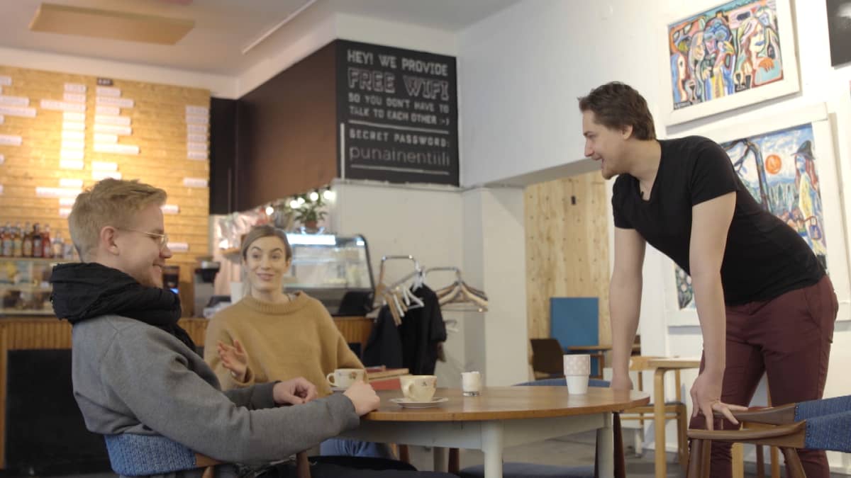 Jevgeni Särki juttelee ihmisille kahvilassa.