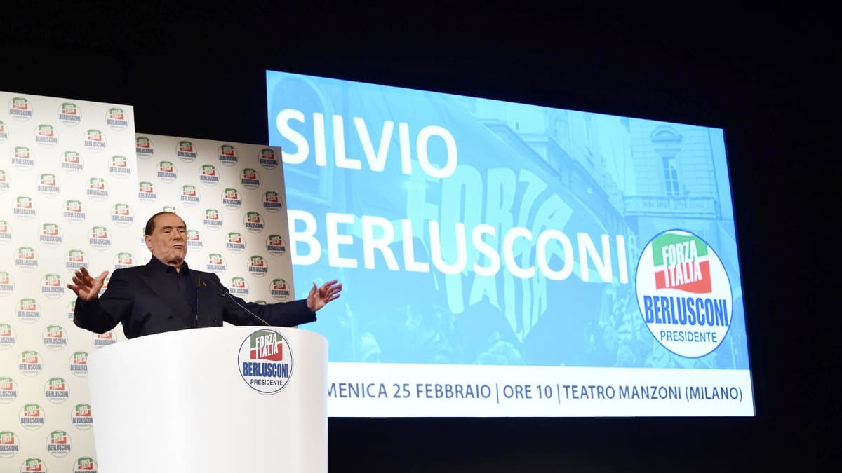 Silvio Berlusconi puhujanpöntössä, lavan taustalle on heijastettu hänen nimensä.