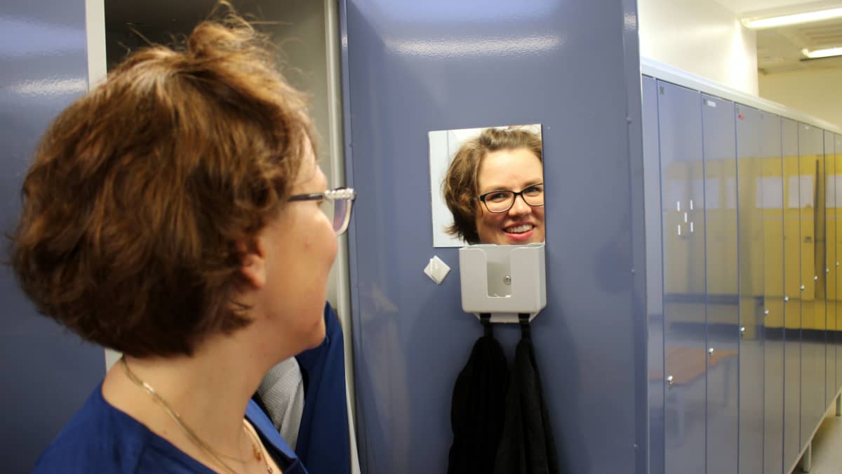 Sairaanhoitaja Riitta Mertanen sairaalan pukuhuoneessa