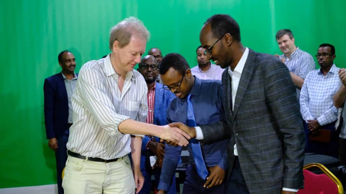 Vikesin koordinaattori Peik Johansson, Somalian viestintäministeriön kansliapäällikkö Abdirahman Yusuf al-Adala ja Somalian kansallistelevision johtaja Liban Abdi Ali virallisissa tunnelmissa.