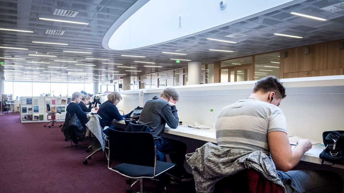 Opiskelijat lukevat kirjastossa