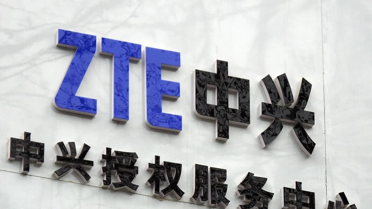 sinisellä tekstillä seinässä luke ZTE, mustalla kiinalaisia merkkejä.