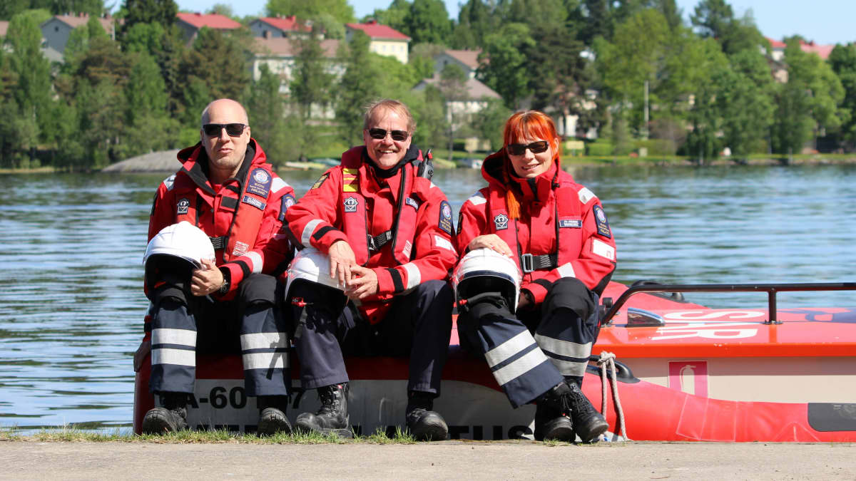 Savonlinnan Järvpelastajien Matti Karhu, Esa Hirvonen ja Anne Kosonen istumassa veneen reunalla.