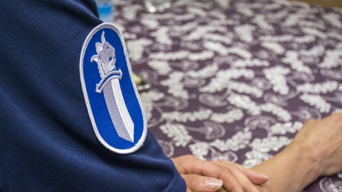 Poliisi istuu pöydän ääressä.