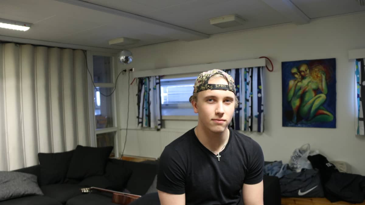 Tuomas Hartikainen istuu Joensuun lyseon lukion kahvion sohvalla