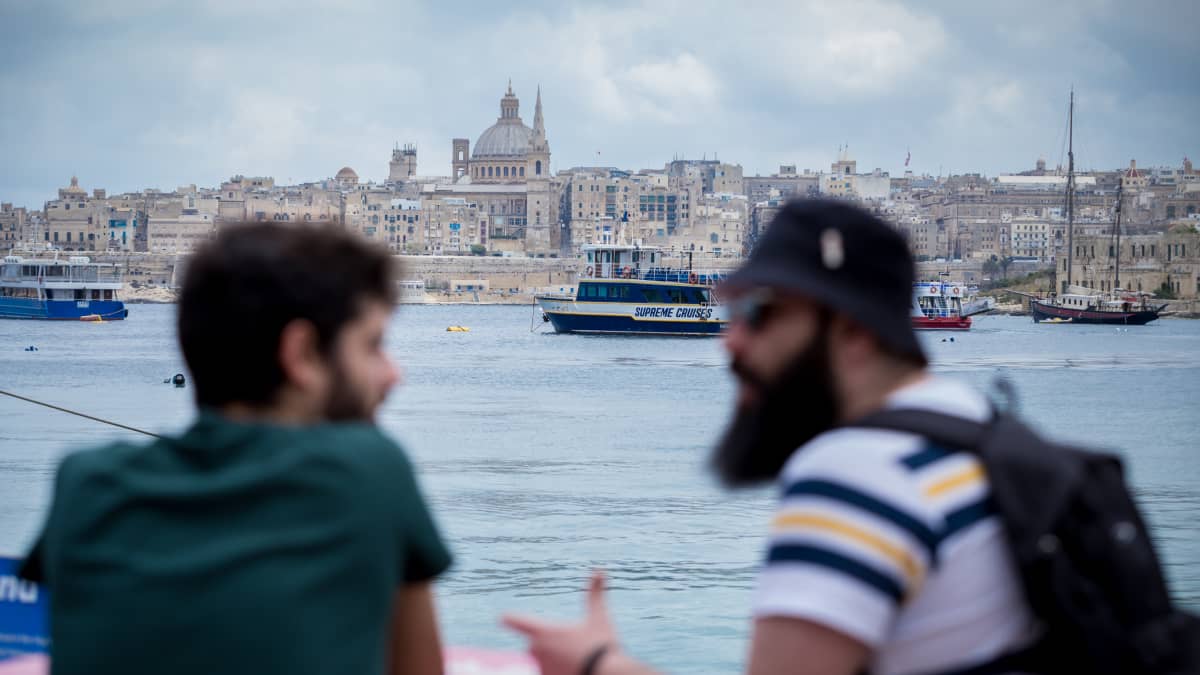 Nuoria etualalla, taustalla Vallettan kaupungin siluetti