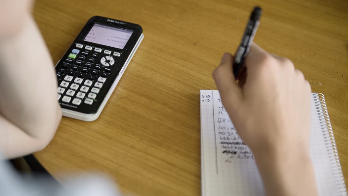 Nuori laskee matematiikan tehtäviä funktiolaskimella.