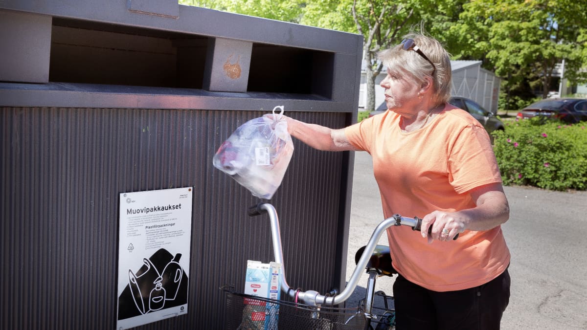 kuvassa nainen kierrättää muovia