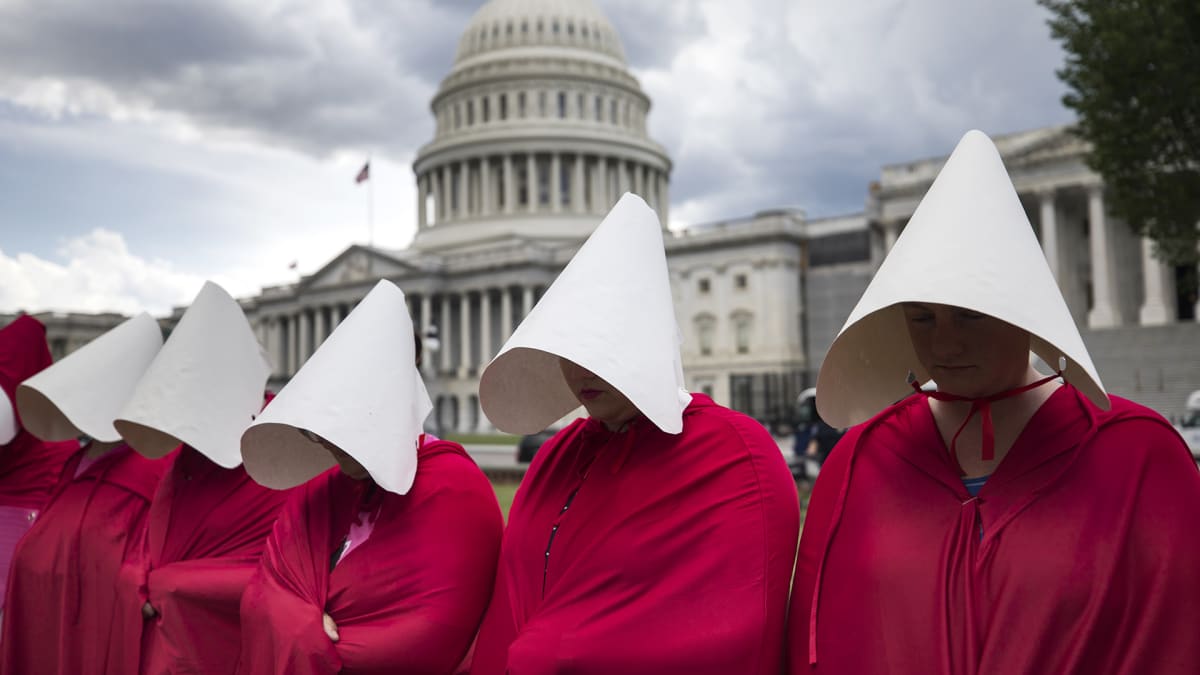 Handmaid's Tale -sarjan synnyttäjiksi pukeutuneet naiset osoittavat mieltään valkoisen talon edustalla Washingtonissa.