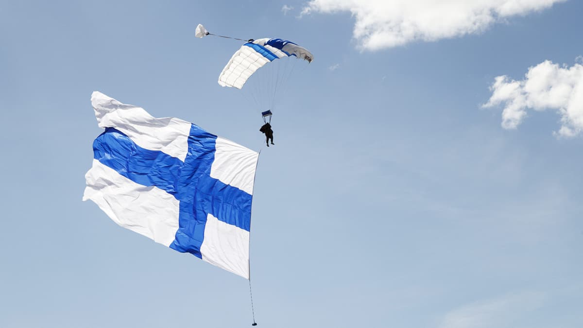 Jättimäisen Suomen lipun kanssa liitävä laskuvarjohyppääjä ja viikon muita  uutiskuvia | Yle Uutiset
