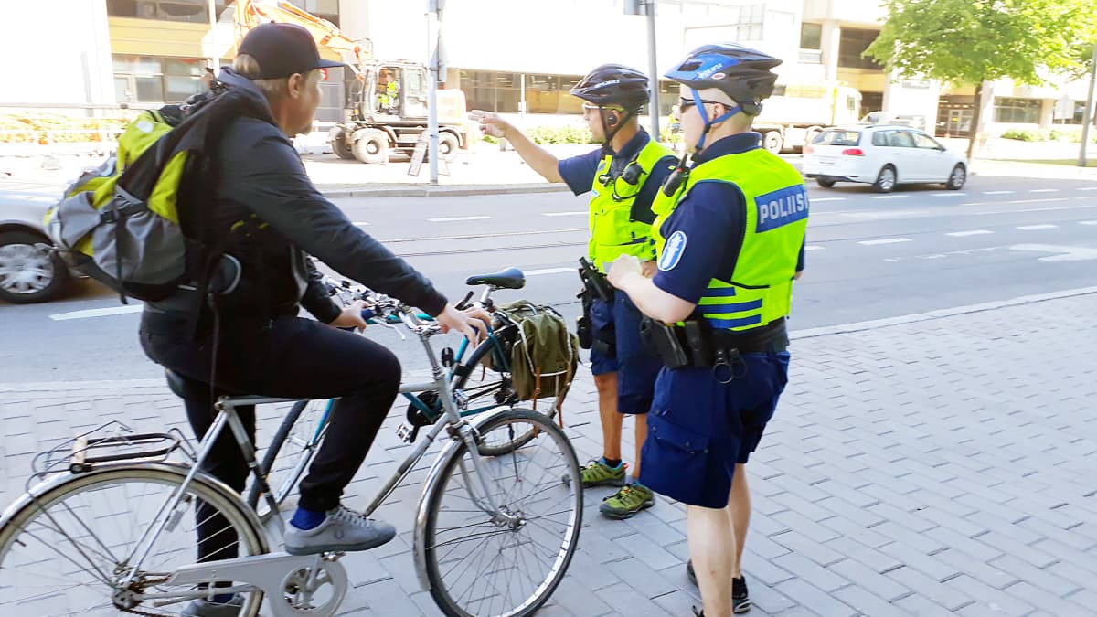poliisit neuvomassa pyöräilijää