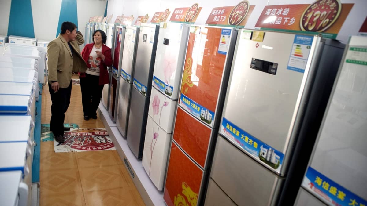 Kiinalainen pariskunta katselee jääkaappirivistöä.